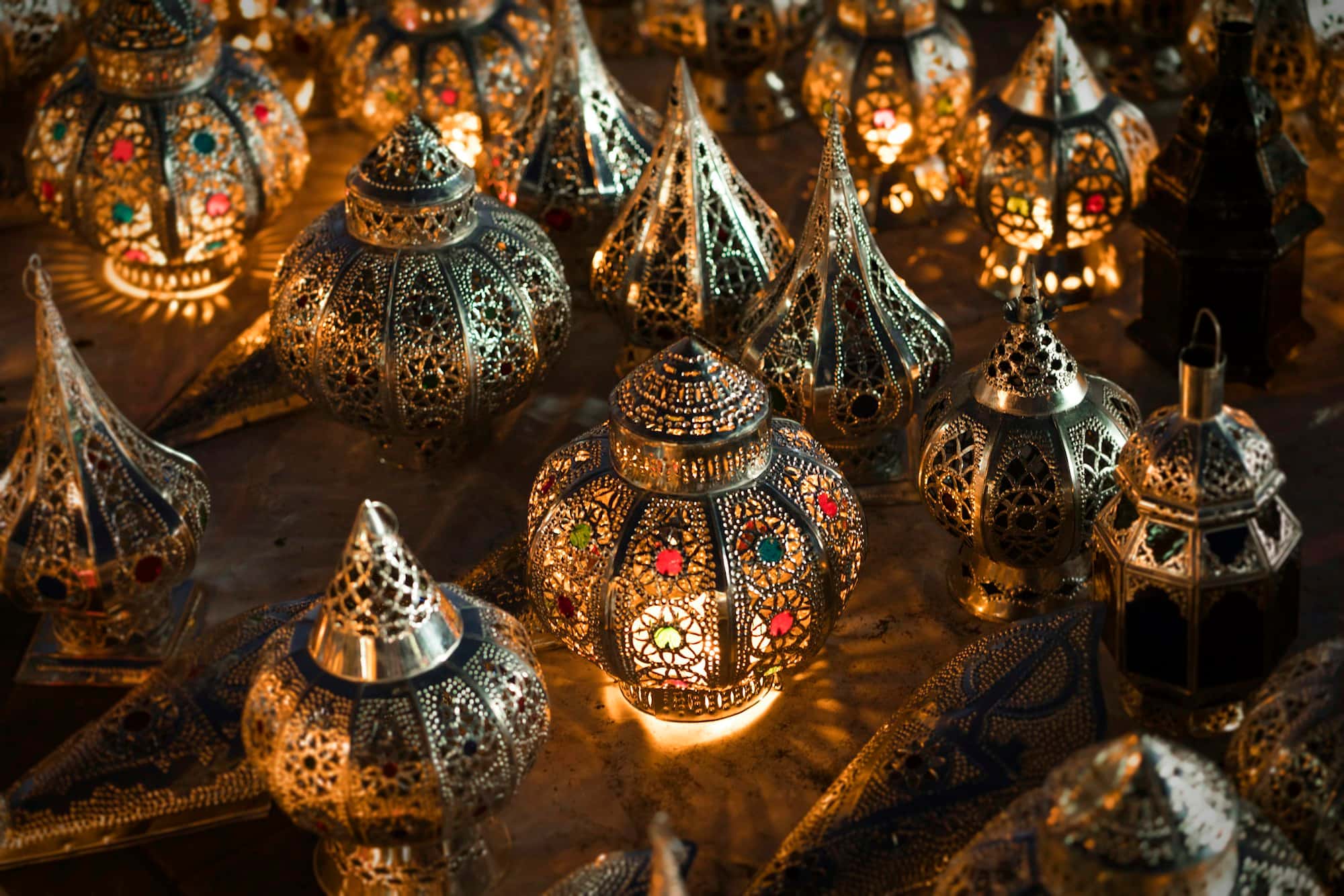 Pierced metal lanterns glowing in a dark room
