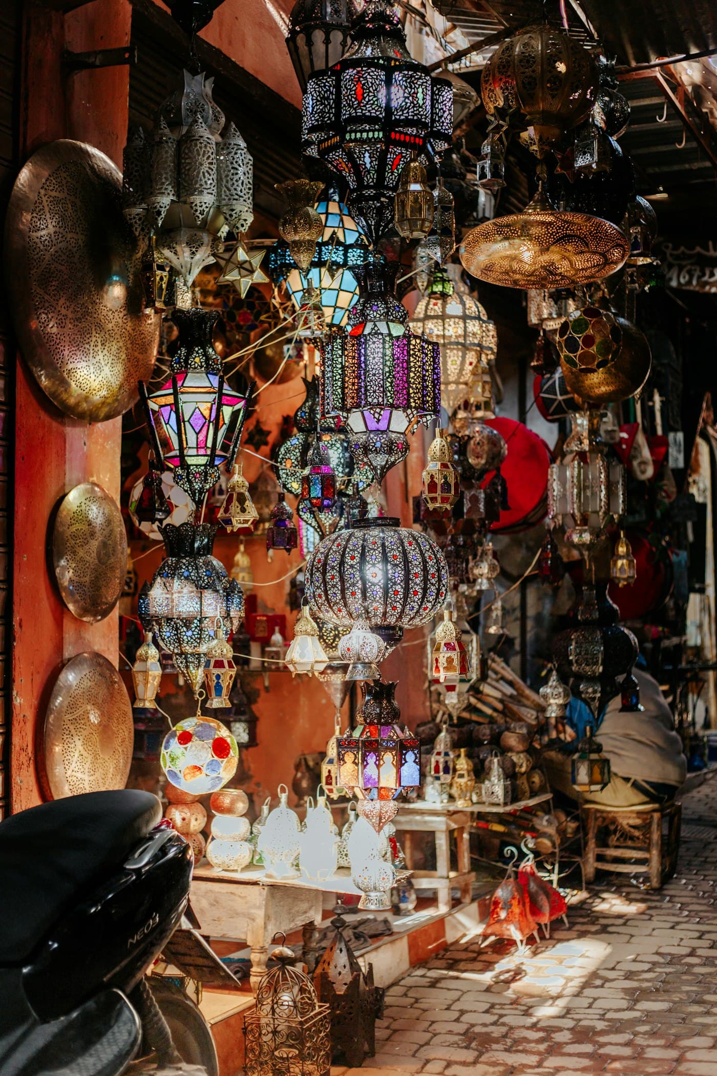 A Moroccan shop hung with lamps and crafts