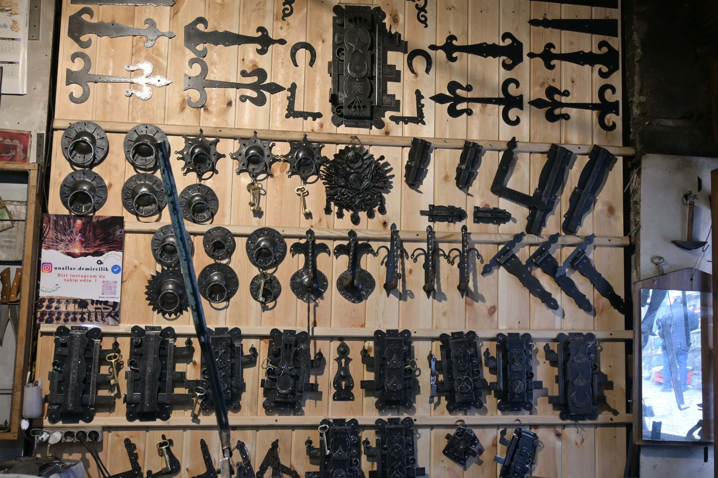 Old hinges, latches and hardware hung on a workshop wall
